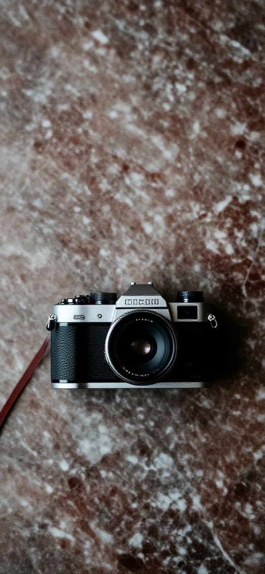 Film Camera On Marble Flatlay Photorealistic Wallpaper